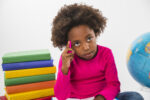kid-thinking-sitting-with-books-in-studio