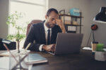 Portrait frustrated afro american collar guy sit desk work computer cant finish career innovation development startup presentation miss deadline feel head ache wear tux tuxedo in workstation