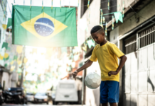 Quando a publicidade brasileira entendeu que o Brasil era a referência Rua decorada com bandeira do Brasil e menino jogando bola.