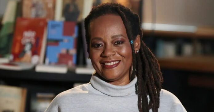 Escritora Eliana Alves Cruz sorrindo com um cenário de livros atrás.