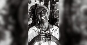 Chef Solange Borges sorridente em foto preto e branco com roupas do candomblé.