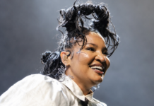 Larissa Luz dirige espetáculo inédito ‘Ancestranças’ em Salvador Larissa Luz sorri durante apresentação musical no palco.