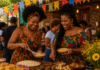 Projeto Cozinha para Todes realiza Arraiá das Pretas em SP Mulheres negras em mesa com comidas juninas no Arraiá das Pretas: Imagem gerada por IA