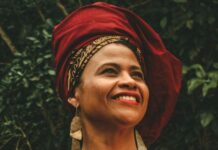 Chef Flávia Alves transformou almoços no quintal de casa em referência da cultura afro em Paraty Flávia Alves usando o turbante vermelho