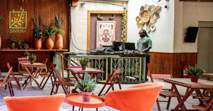 Espaço da Casa Savana com DJ tocando música ao fundo.