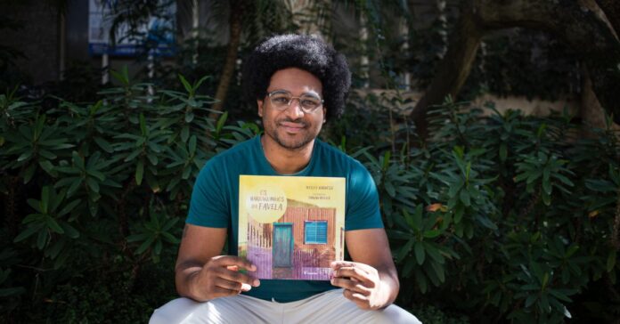 Wesley Barbosa segurando o seu primeiro livro infantil.