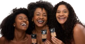 Duas modelos e Rosangela Silva (ao centro), fundadora da Negra Rosa, segurando as novas bases da marca.