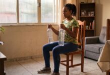 Por que a mulher negra precisa de musculação mesmo trabalhando o dia inteiro? Mulher negra fazendo musculação em casa