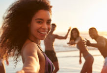 Como preservar o comprimento dos cachos e crespos no verão Mulher negra com cabelo crespo longo no verão